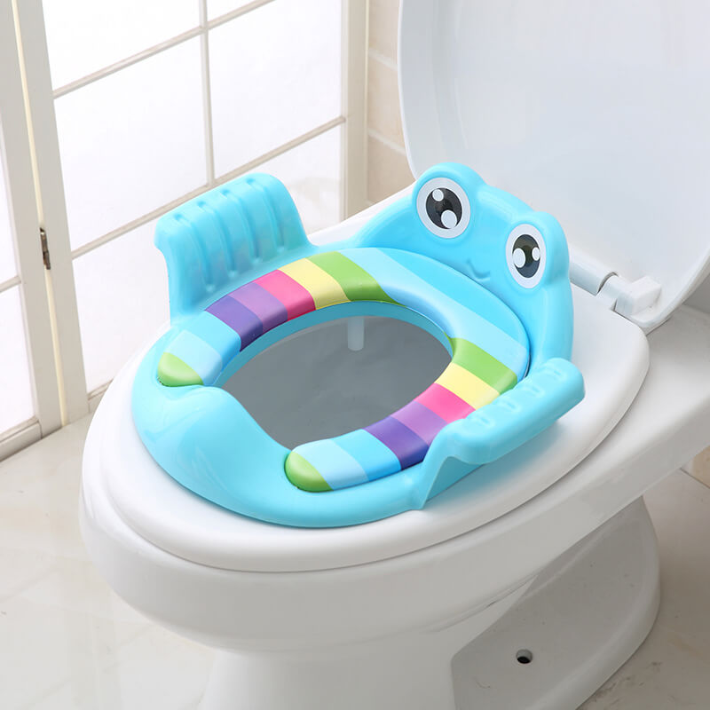Reducteur de toilette enfant grenouille verte avec coussin rembourre multicolore et poignees laterales de securite.
